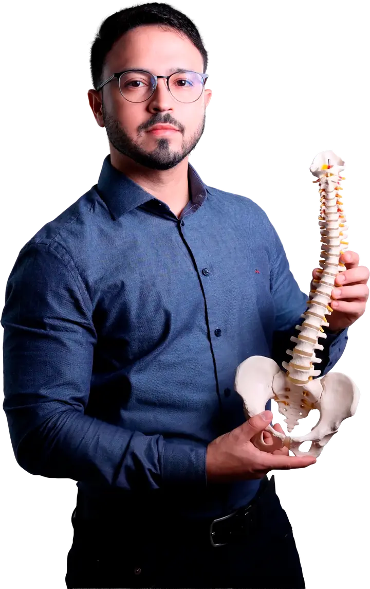 Dr. Caio Siqueira, neurocirurgião, segurando um modelo de coluna vertebral
